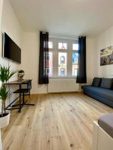 ein Wohnzimmer mit einem blauen Sofa und einem Tisch in der Unterkunft PnT home-stilvolles Apartment in Koblenz