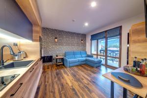 a living room with a blue couch in a kitchen at Home Away From Home Apartment 538 in Smolyan