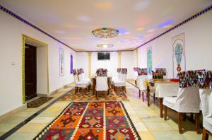 a dining room with a table and chairs and a rug at Bukhara Zaringiz PREMIUM in Bukhara