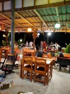 un grupo de personas sentadas en mesas en un restaurante en Baan Panseng Bungalow en Ko Kood