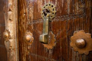 a metal door knocker on a wooden door at Zaringiz Boutique in Bukhara