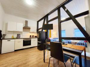 eine Küche und ein Esszimmer mit einem Tisch und Stühlen in der Unterkunft 1 Room Apartment in Burscheid in Burscheid