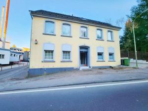 ein gelbes Gebäude an der Straßenseite in der Unterkunft 1 Room Apartment in Burscheid in Burscheid