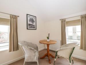 ein Esszimmer mit einem Tisch und 2 Stühlen in der Unterkunft Stables Cottage in Melksham