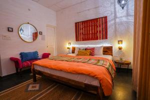 Un dormitorio con una cama grande y un espejo. en The Autumn Home - Cafe & Homestay, en Bīr