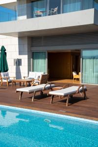 a swimming pool with chaise lounges next to a building at ON'LIVE HOTEL in Cesme
