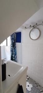 a white bathroom with a sink and a mirror at Vacation Home Kovachnica (Blacksmith`s shop) in Vrbnik