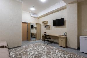 a room with a desk and a tv on a wall at ABIS Palace Hotel in Tashkent
