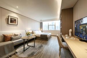 - un salon avec un lit, un canapé et une table dans l'établissement CM Serviced Apartment Shenzhen Dongmen, à Shenzhen