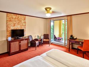 ダイデスハイムにあるMAXX by Steigenberger Deidesheimのベッドとテレビが備わるホテルルームです。