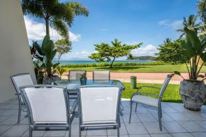 a patio with a table and chairs and a view of the ocean at Magnetic Docks Townhouse 5 in Nelly Bay