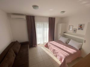 - une chambre avec un lit, un canapé et une fenêtre dans l'établissement Apartment Luna, à Drvenik