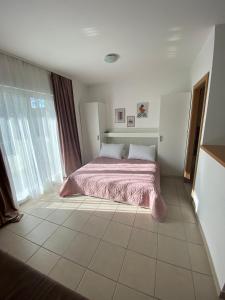 - une chambre avec un lit et une couverture rose dans l'établissement Apartment Luna, à Drvenik