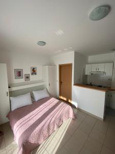 a bedroom with a large bed and a kitchen at Apartment Luna in Drvenik