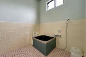 Asso的住宿－Guest House Koyama -南紀白浜 ゲストハウス 小山- ペット可，带浴缸和卫生间的浴室。