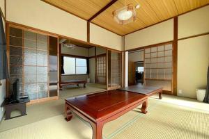 een grote kamer met een houten tafel. bij Guest House Koyama -南紀白浜 ゲストハウス 小山- ペット可 in Asso