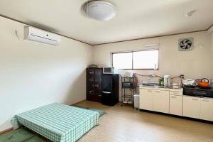 Habitación con cocina y cama. en Guest House Koyama -南紀白浜 ゲストハウス 小山- ペット可 en Asso