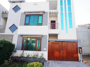 a house with a wooden gate in front of it at Welcome Guest House in Karachi