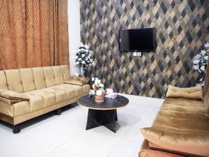 a living room with a couch and a table at Welcome Guest House in Karachi