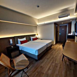 una camera d'albergo con letto e tavolo di Grand Zuri Pekanbaru a Pekanbaru