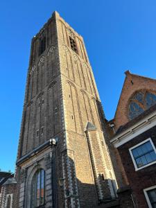 una torre dell'orologio alta in cima a un edificio di Monkey Tree Stay a Schiedam