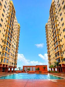 a pool in the middle of two tall buildings at N'dnie Homestay Pelangi Mall Condominium in Kota Bharu