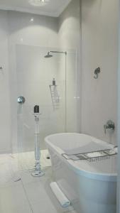a bathroom with a shower and a tub and a toilet at Kowie River Guest House in Port Alfred