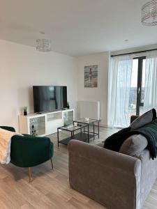 a living room with a couch and a tv at NEW Modern 2 Bedroom Apartment! in Dagenham