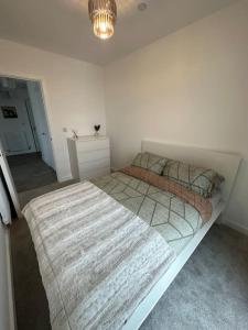 a bedroom with two beds and a chandelier at NEW Modern 2 Bedroom Apartment! in Dagenham