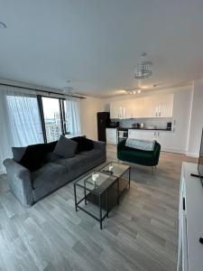 a living room with a couch and a table at NEW Modern 2 Bedroom Apartment! in Dagenham