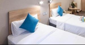 香港にあるmetacity livingの- ホテルルーム内のベッド2台(青い枕付)