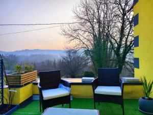 2 Stühle und ein Tisch auf einem Balkon mit Aussicht in der Unterkunft Dans les étoiles in Cuttura