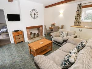 a living room with two couches and a fireplace at Dairy Cottage in Newport