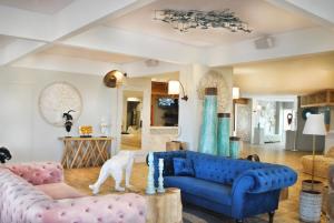 a living room with a blue couch and pink furniture at CAPAO Beach Hôtel in Cap d'Agde
