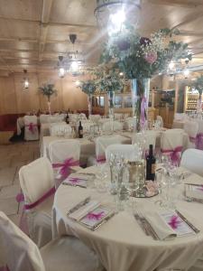 ein Esszimmer mit weißen Tischen, weißen Stühlen und Blumen in der Unterkunft Boscone Suite Hotel in Madesimo