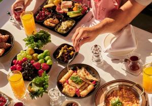 a table with many plates of food on it at Divan Bodrum Palmira in Golturkbuku