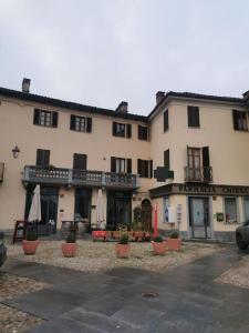 a large building with umbrellas in front of it at Casa San Pietro centro storico in Castagnole Lanze
