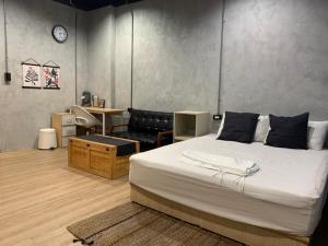 - une chambre avec un grand lit et un canapé dans l'établissement Wuhoo House, à Kaohsiung