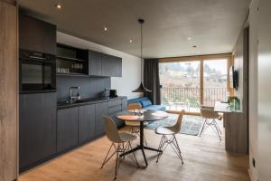 a kitchen and living room with a table and chairs at Livingreen Residences in Feldkirch
