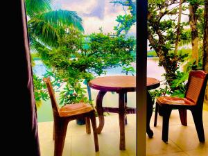 a wooden table and two chairs and a table and a table at New Heaven in Ambalangoda