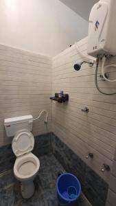 a bathroom with a toilet and a camera on the wall at Backpackers hostel in Pune