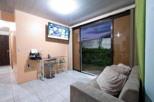 a living room with a couch and a desk and a television at Jordi´s House in Fortuna
