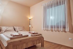 um quarto com uma cama com um candeeiro e uma janela em Vadvirág Vendégház em Izsák