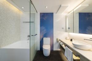 a bathroom with a toilet and a sink at Lodgewood by Nina Hospitality Mong Kok in Hong Kong