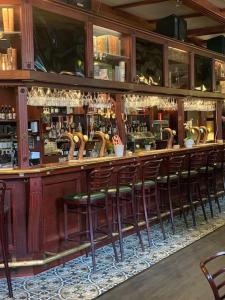 a bar with a row of wooden stools at Best Guest Vandrarhem in Norrköping