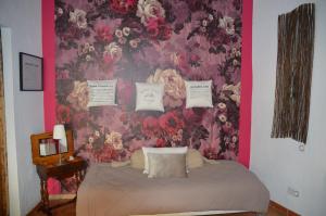 um quarto com um papel de parede floral e uma cama em La Paillère chambres d hôtes em Mus