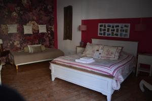 um quarto com uma cama com uma parede vermelha em La Paillère chambres d hôtes em Mus