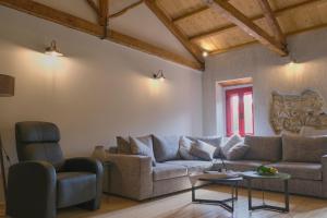 sala de estar con sofá y silla en Yasemia Wood & Stone Villa en Makris Gialos