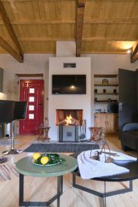 a living room with a table and a fireplace at Yasemia Wood & Stone Villa in Makris Gialos