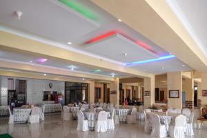 a banquet hall with white tables and white chairs at RedDoorz at H&W Hotel Solo in Solo